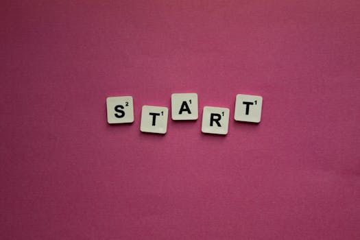 Scrabble tiles spelling 'START' against a pink background. Perfect for motivational themes.